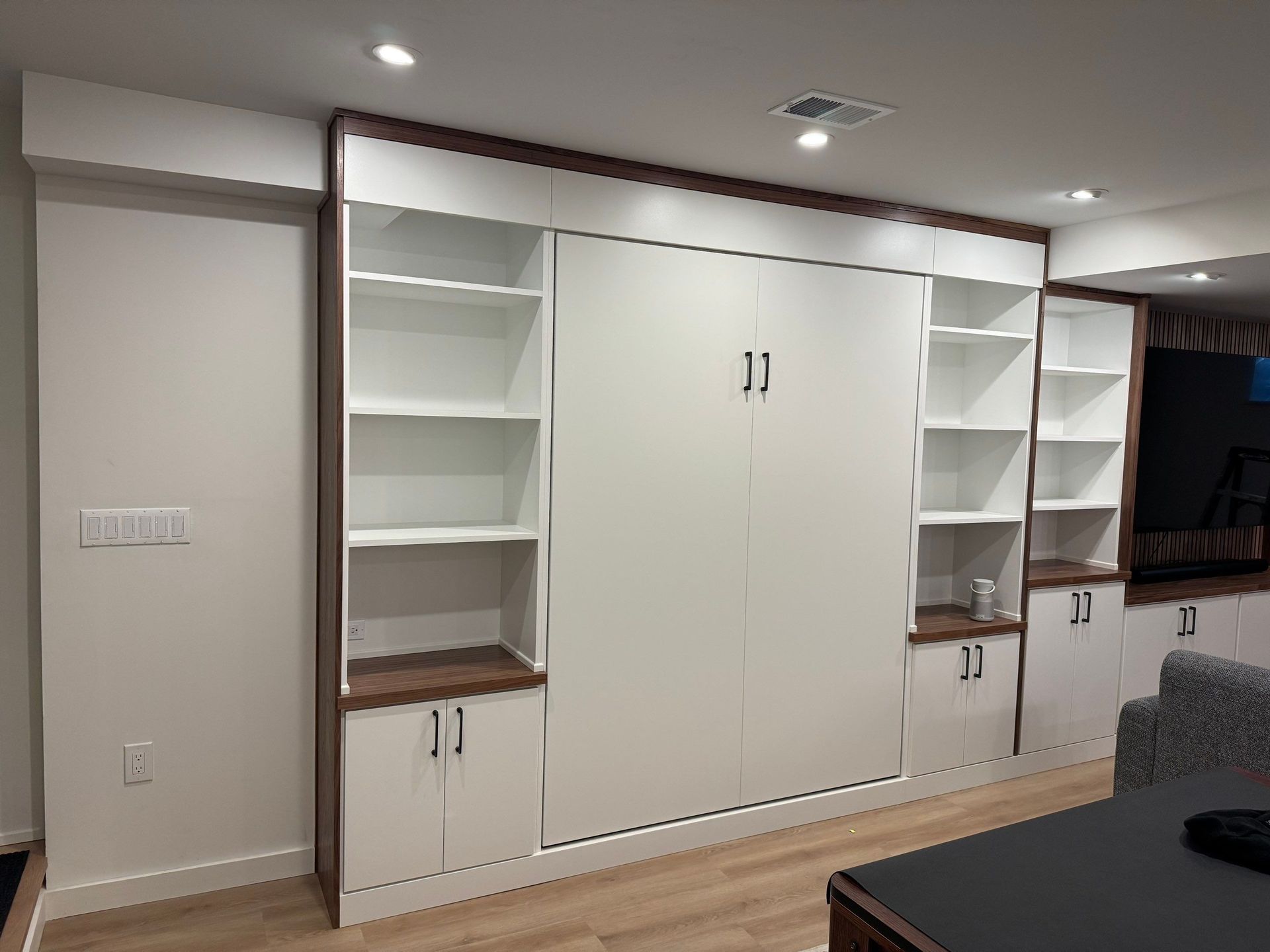 Custom Murphy bed installation showcasing a space-saving wall bed with built-in cabinetry.