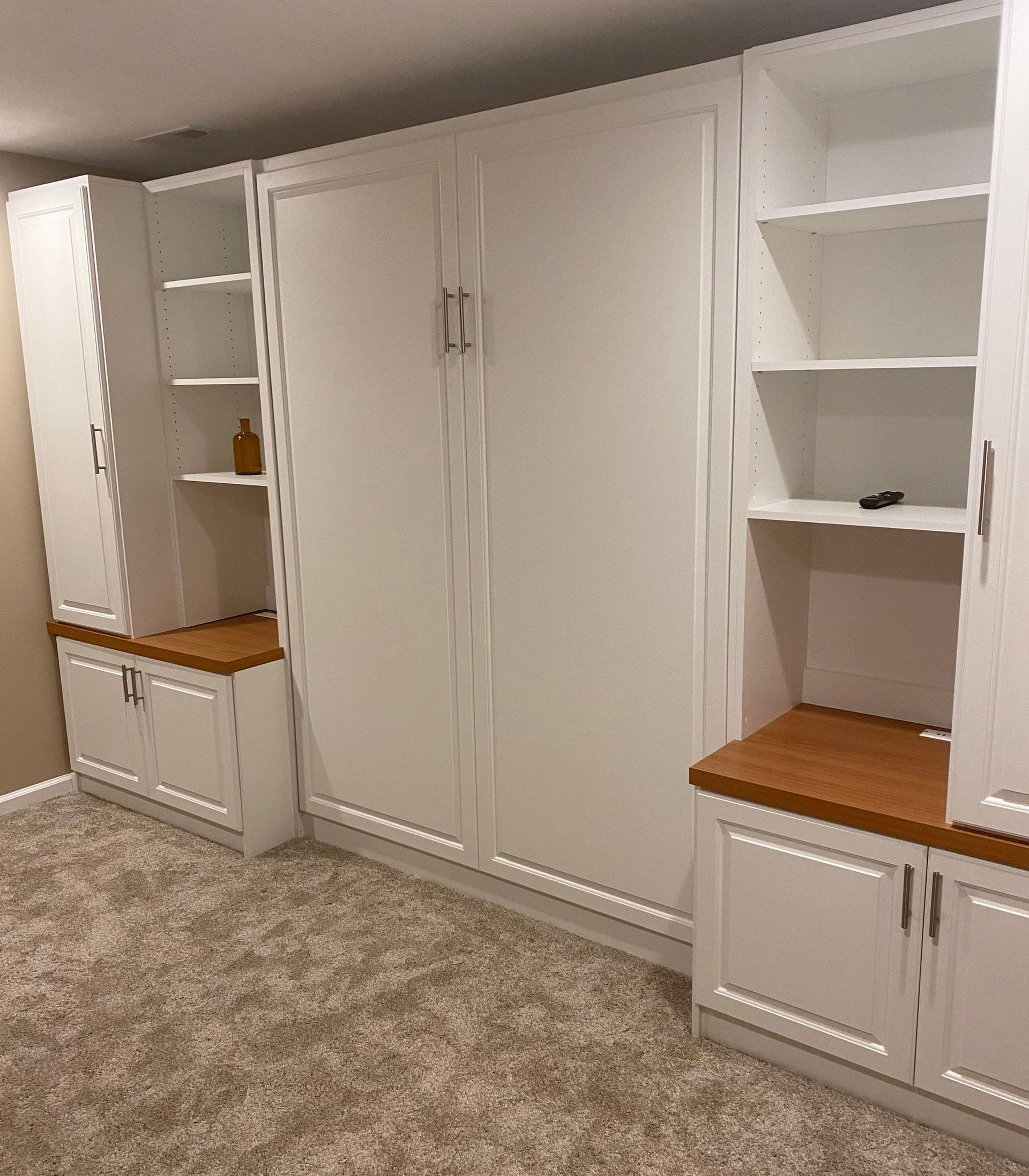 Murphy bed in a finished living room designed as a versatile space with built-in storage and seating.