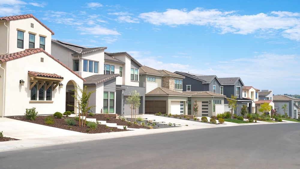 A row of houses are lined up on the side of a street.