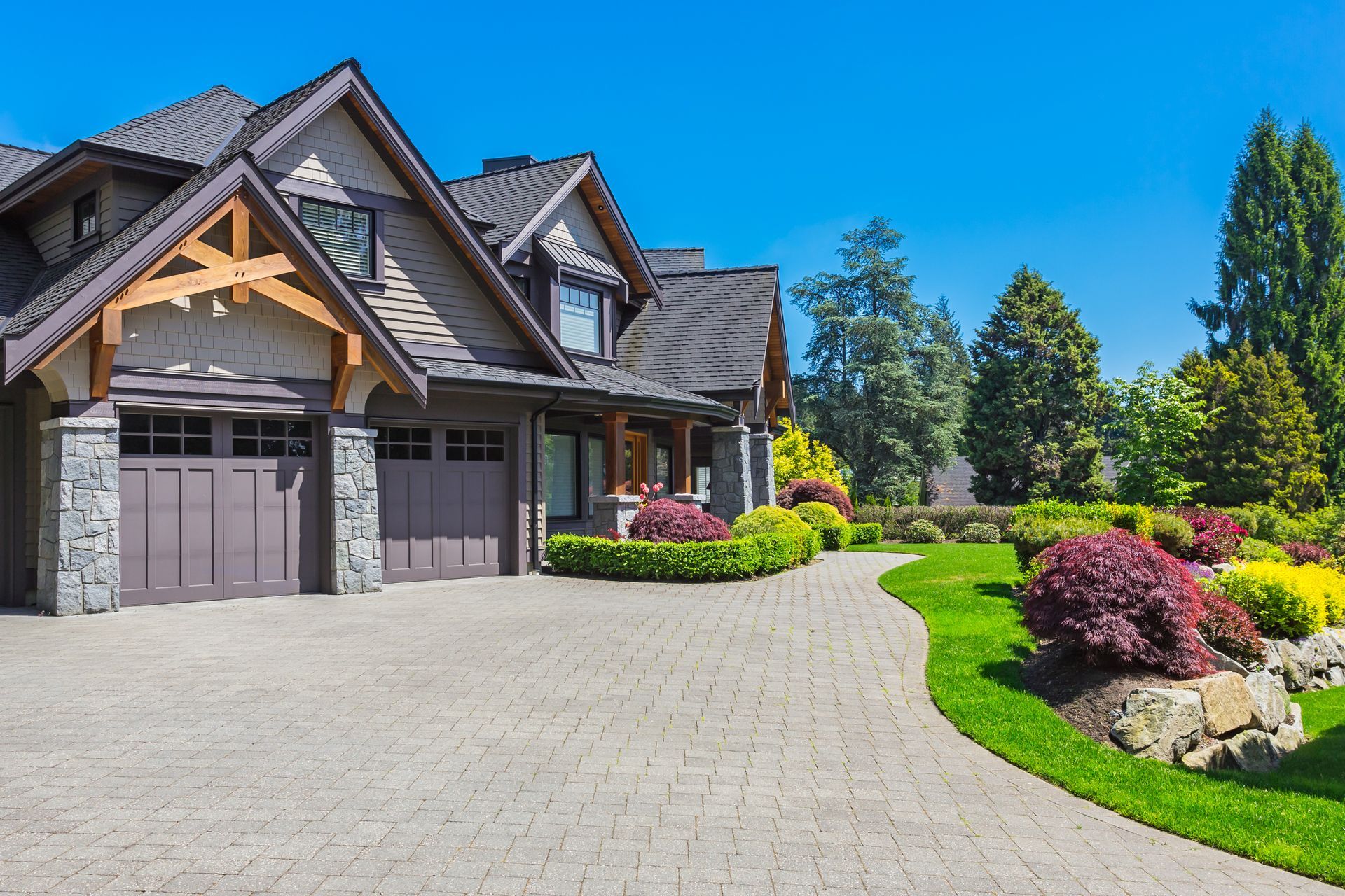 A large house with a large driveway and a large garage.