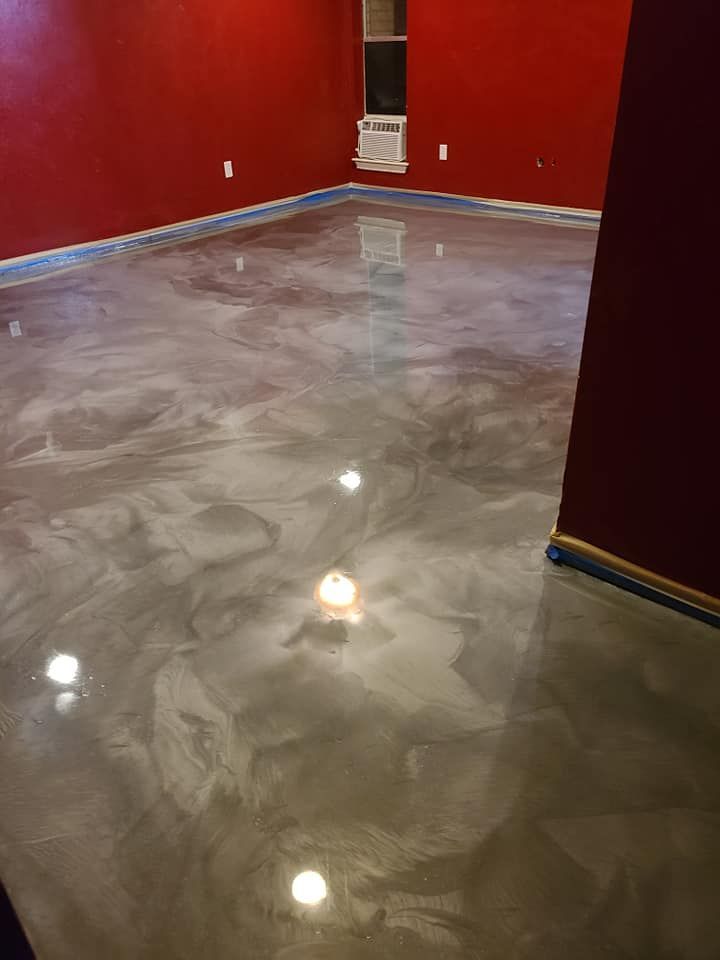 Metallic gray epoxy floor in a room with red walls, near a window.