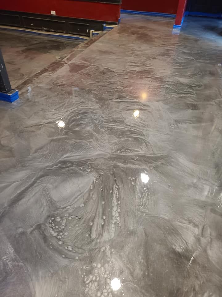 Metallic silver epoxy floor reflecting overhead lights.
