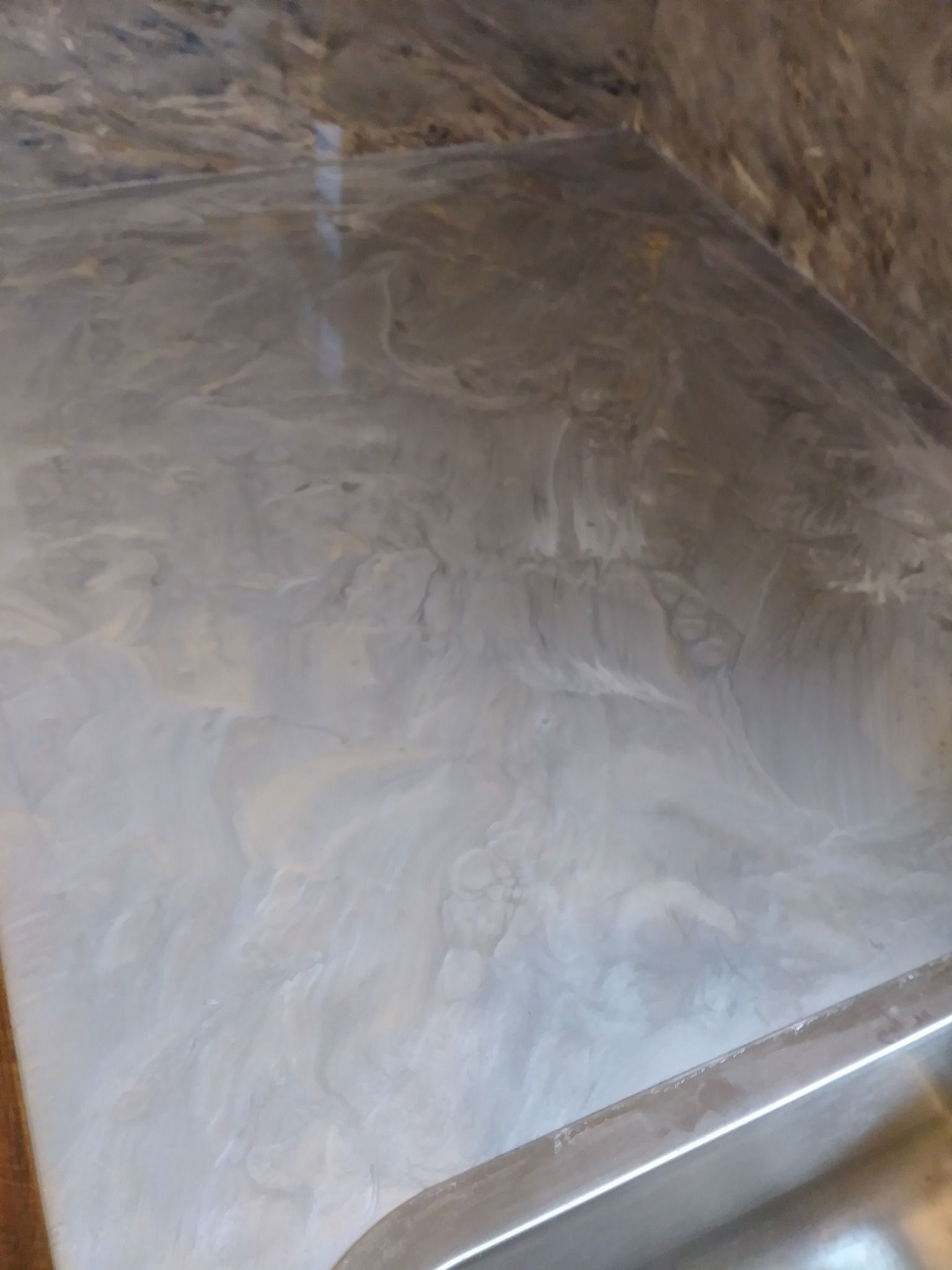 Silver epoxy floor with swirling patterns, reflecting light.