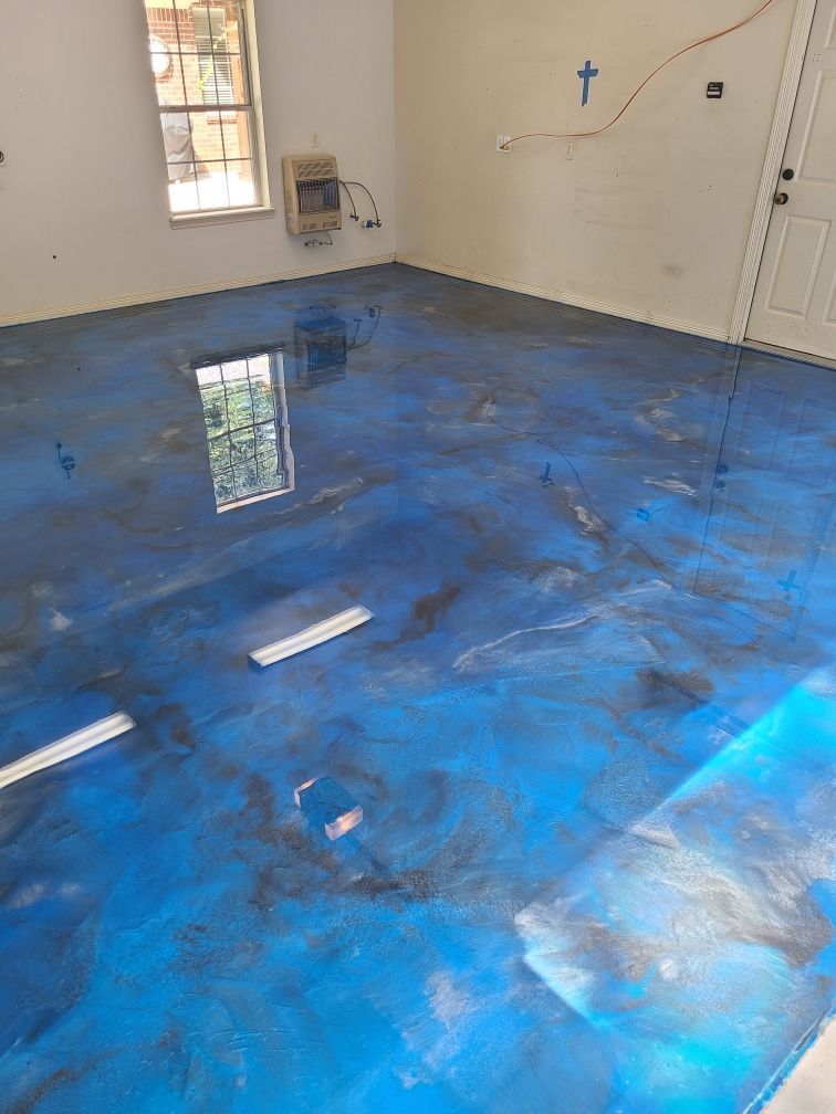 Blue and gray metallic epoxy flooring in a room with a window and door.