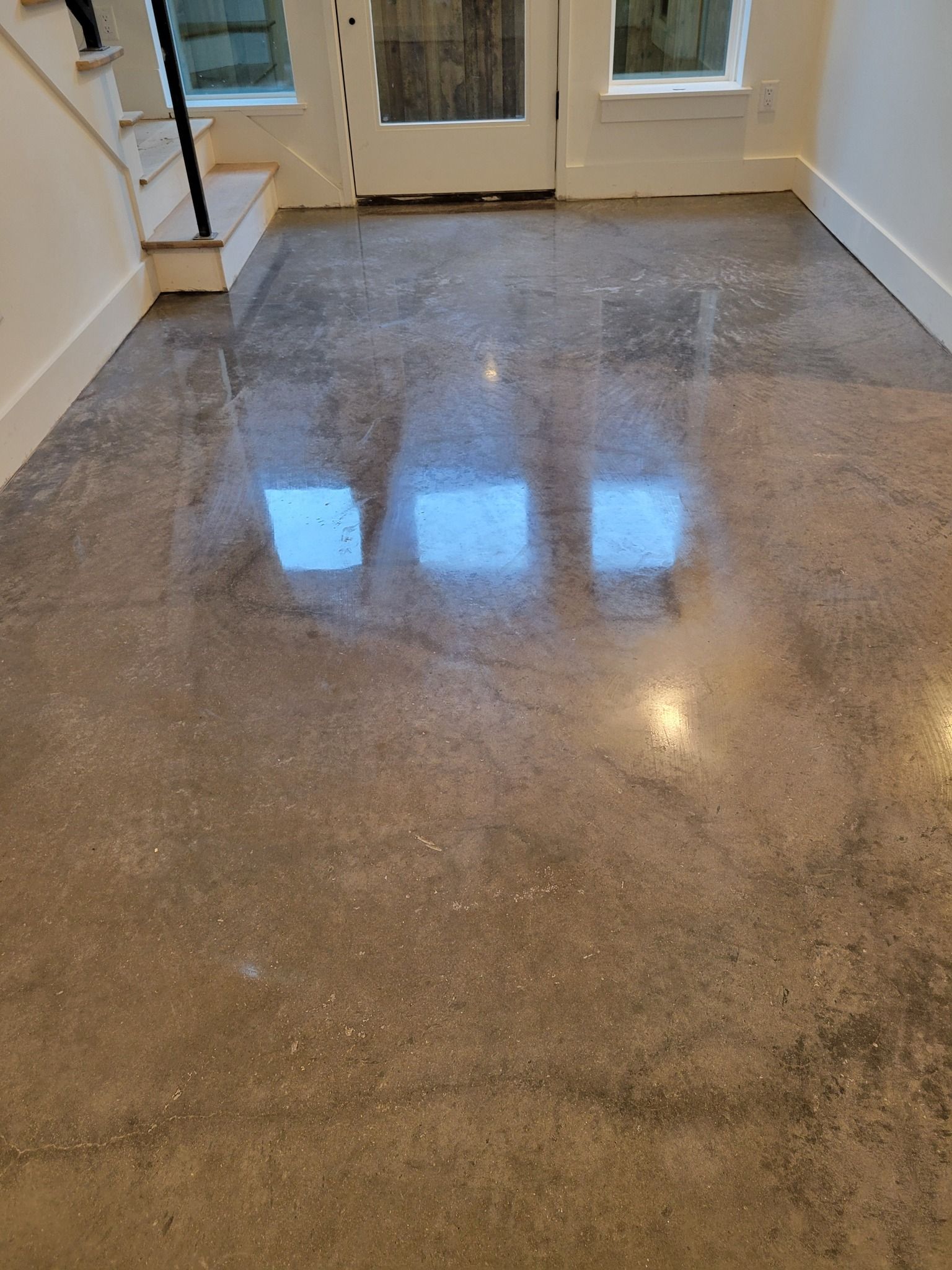 Polished concrete floor reflecting light from windows.
