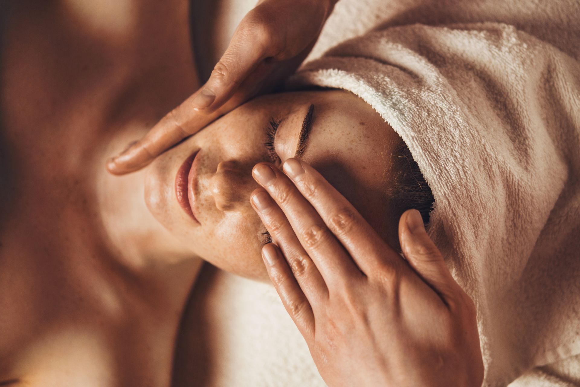 Top view of smiling freckled woman relaxing during myofascial massaging therapy.