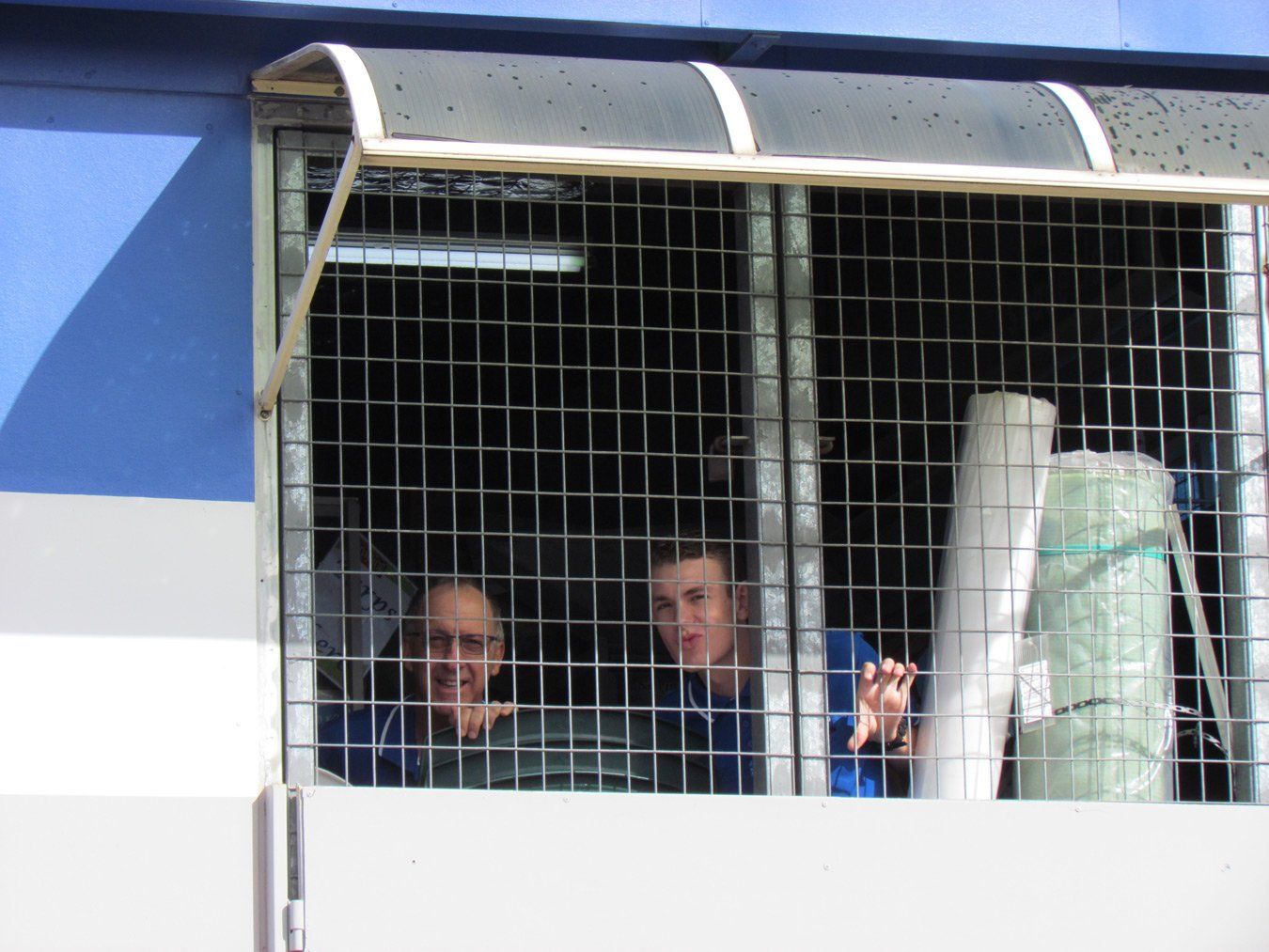 2 men behind a screen window