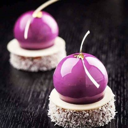 Deux desserts violets sont posés sur une table en bois.