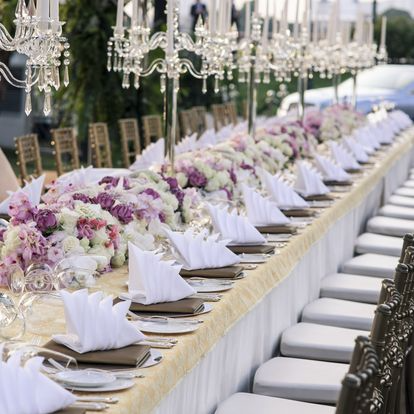 Une longue table avec des fleurs et des bougies dessus