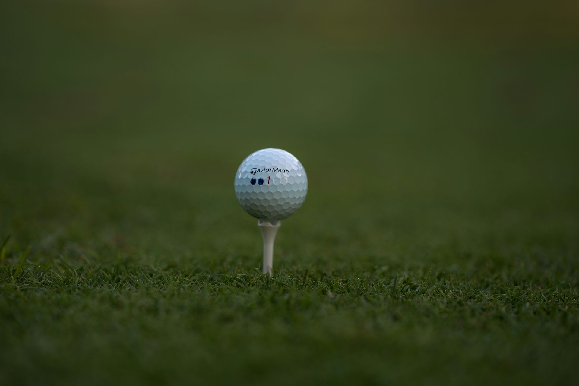 Golf ball on a tee in green grass.