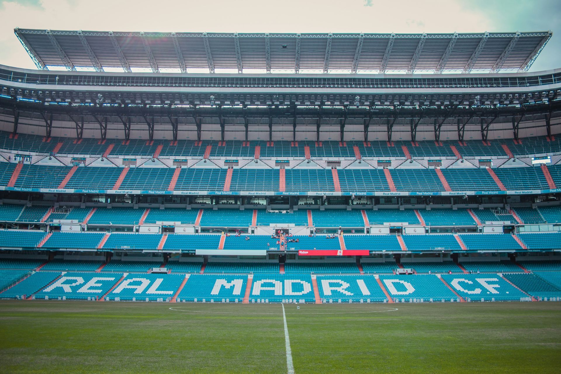 An empty soccer stadium with the word real madrid written on the field.