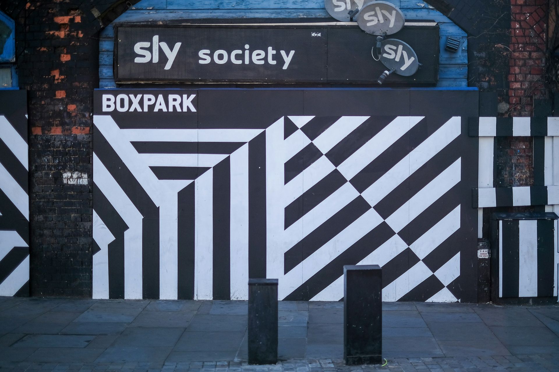 Exterior view of Boxpark with black and white geometric design, beneath 