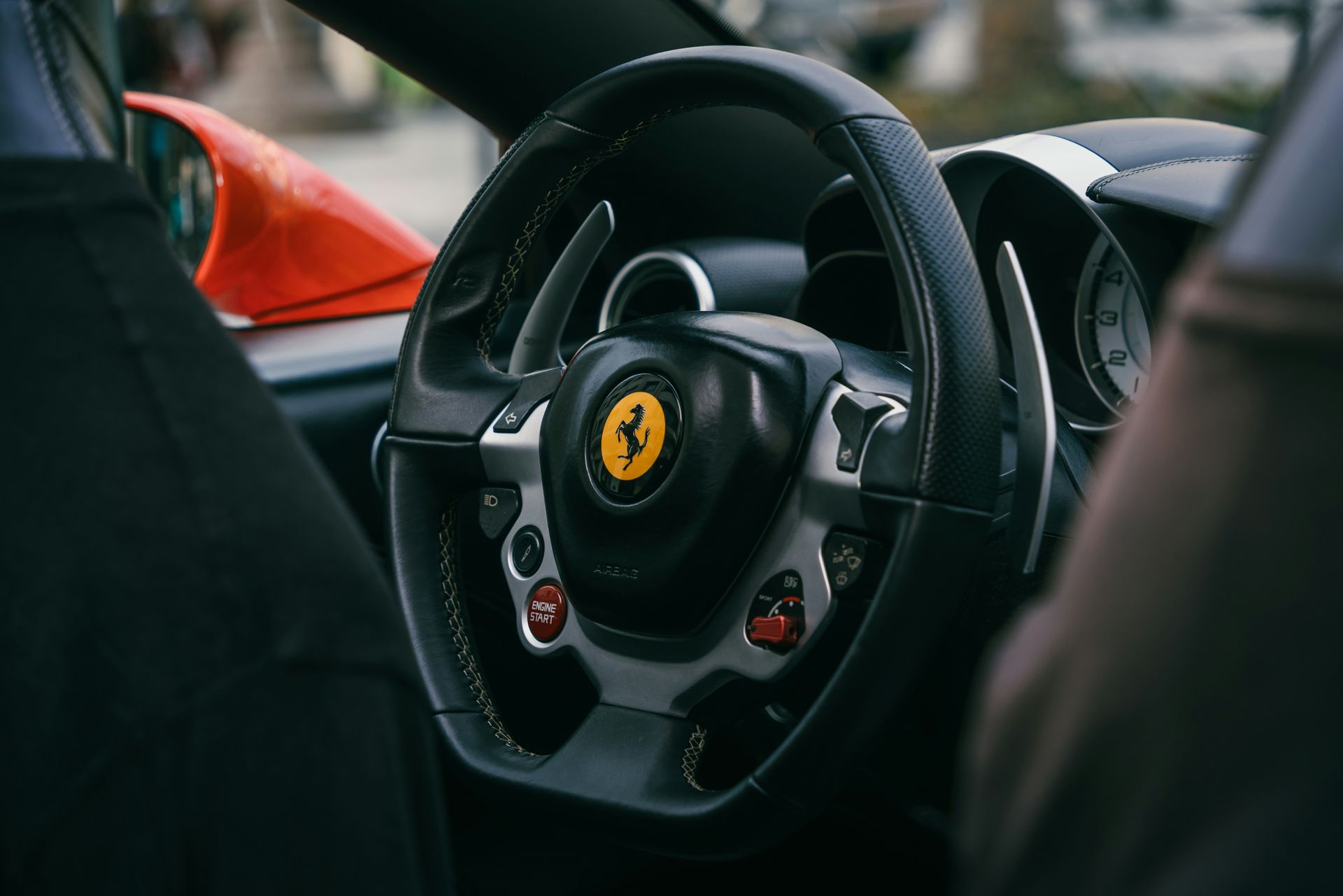 A close up of a steering wheel in a ferrari car.