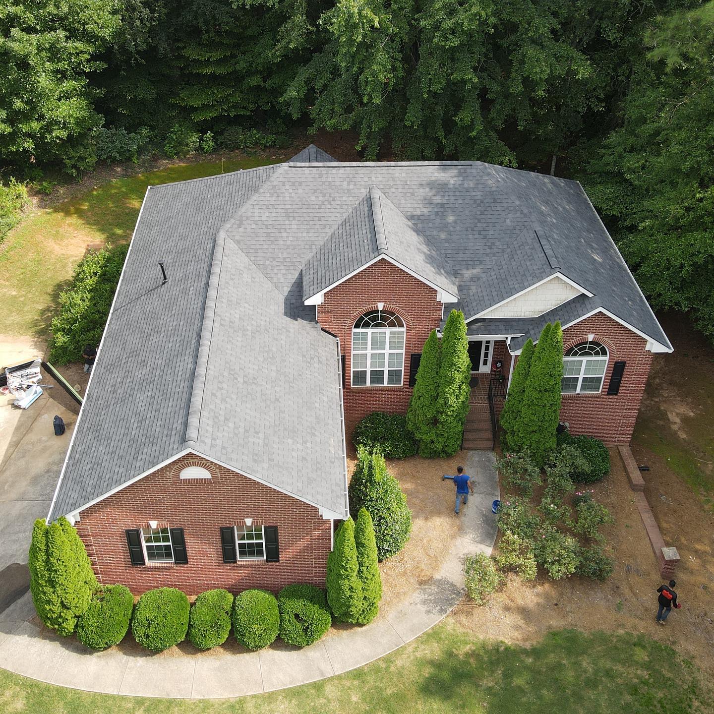 An aerial view of a large brick house with a gray roof in Bowdon Ga