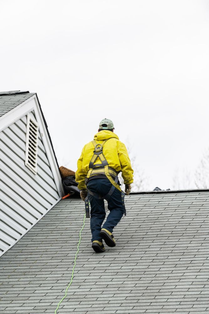 A man is standing on top of a roof in Carrollton Ga.