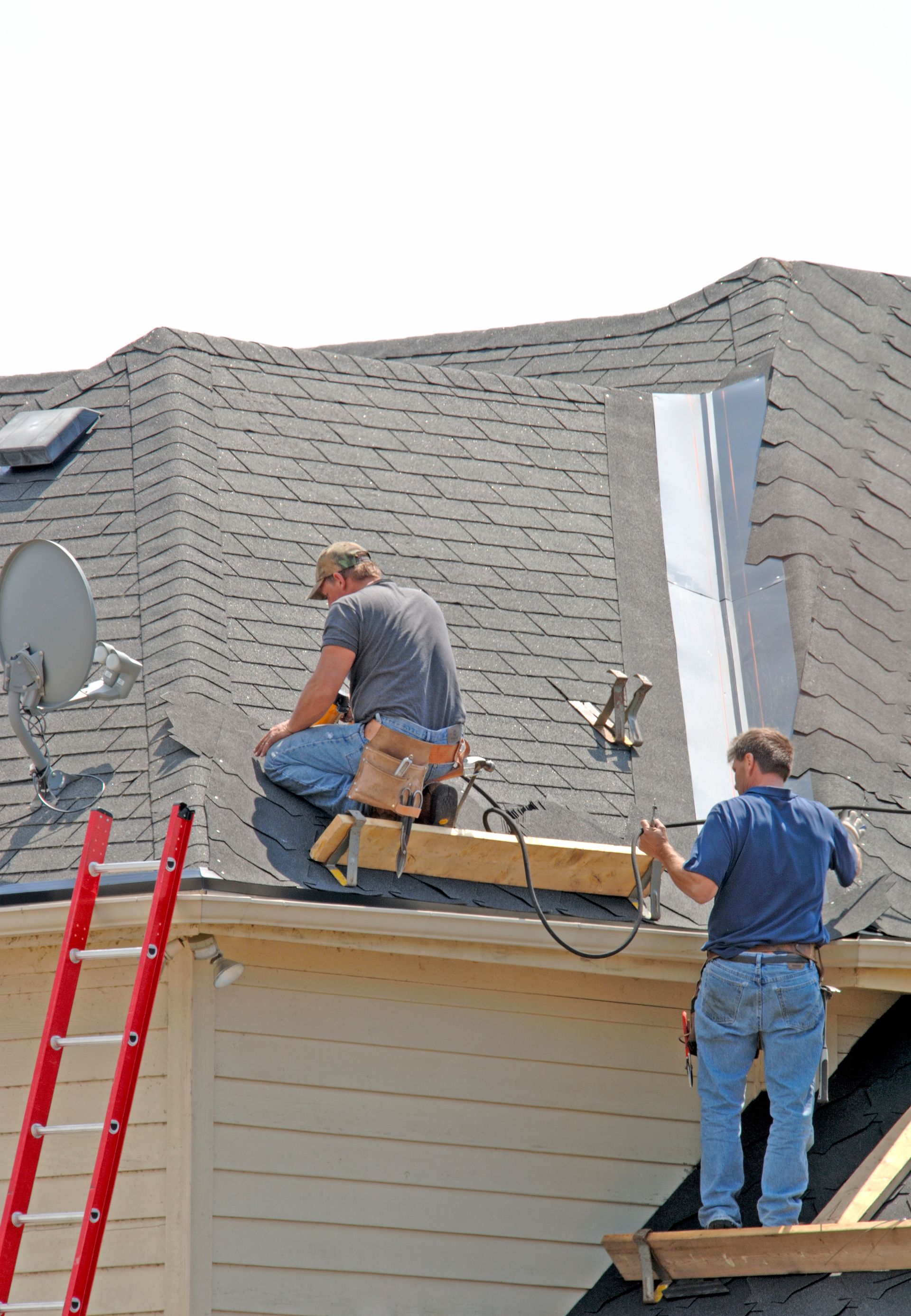 Two men are working on the roof of a house in Haralson Ga.