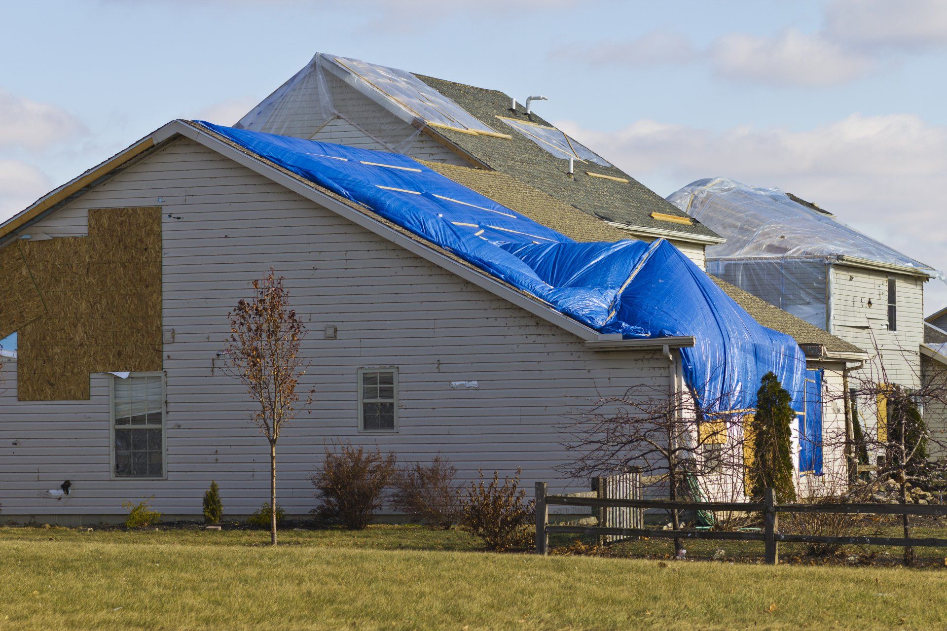 A storm damaged house in Carrollton Ga with a blue tarp on top of it