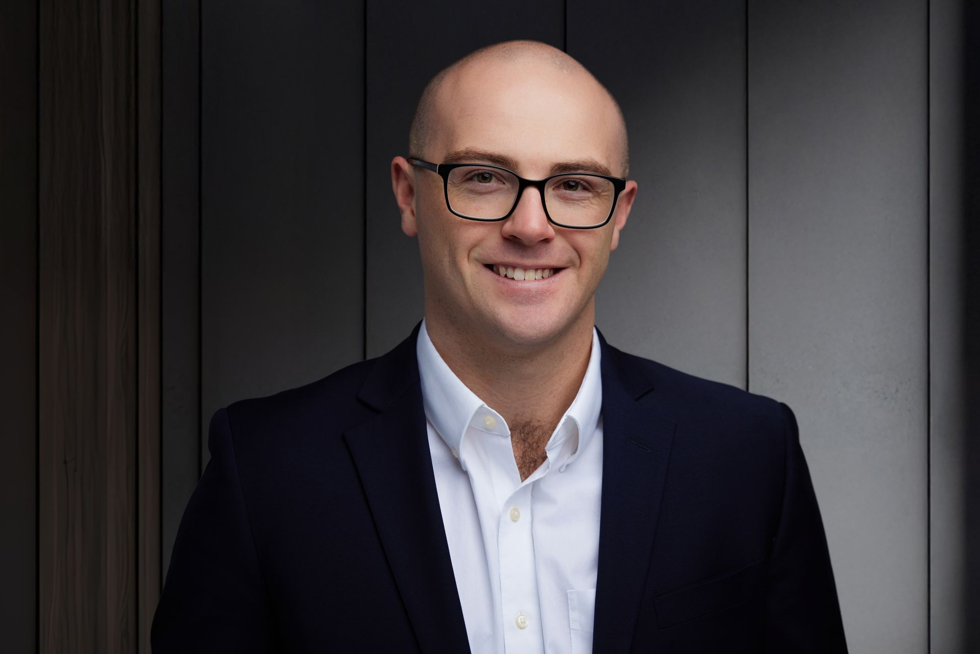 A man in a suit and tie is smiling for the camera.