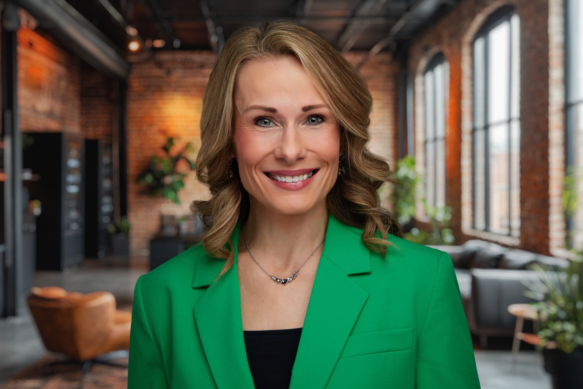 A woman in a suit and striped shirt is smiling for the camera.