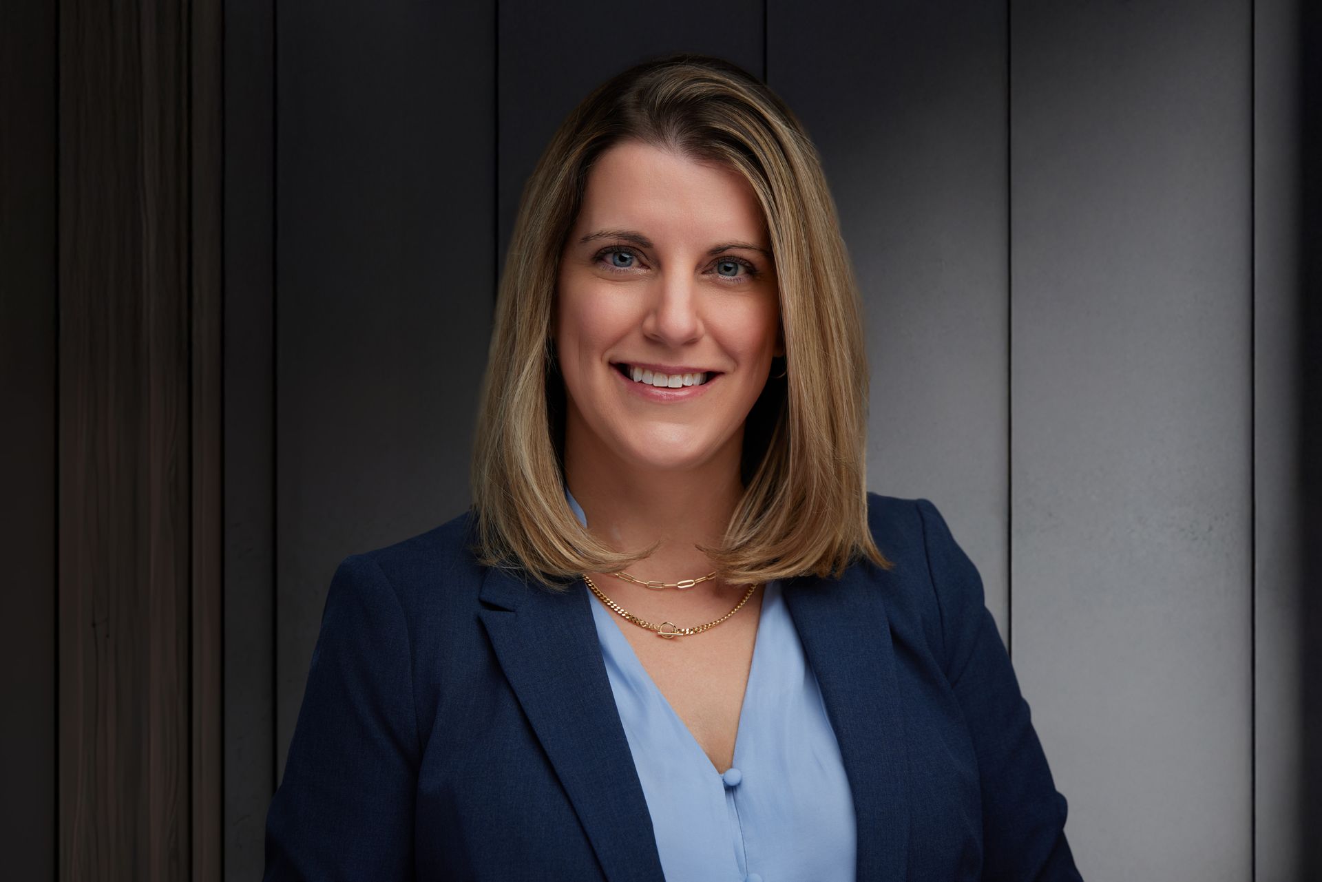 A woman in a pink shirt is smiling for the camera.