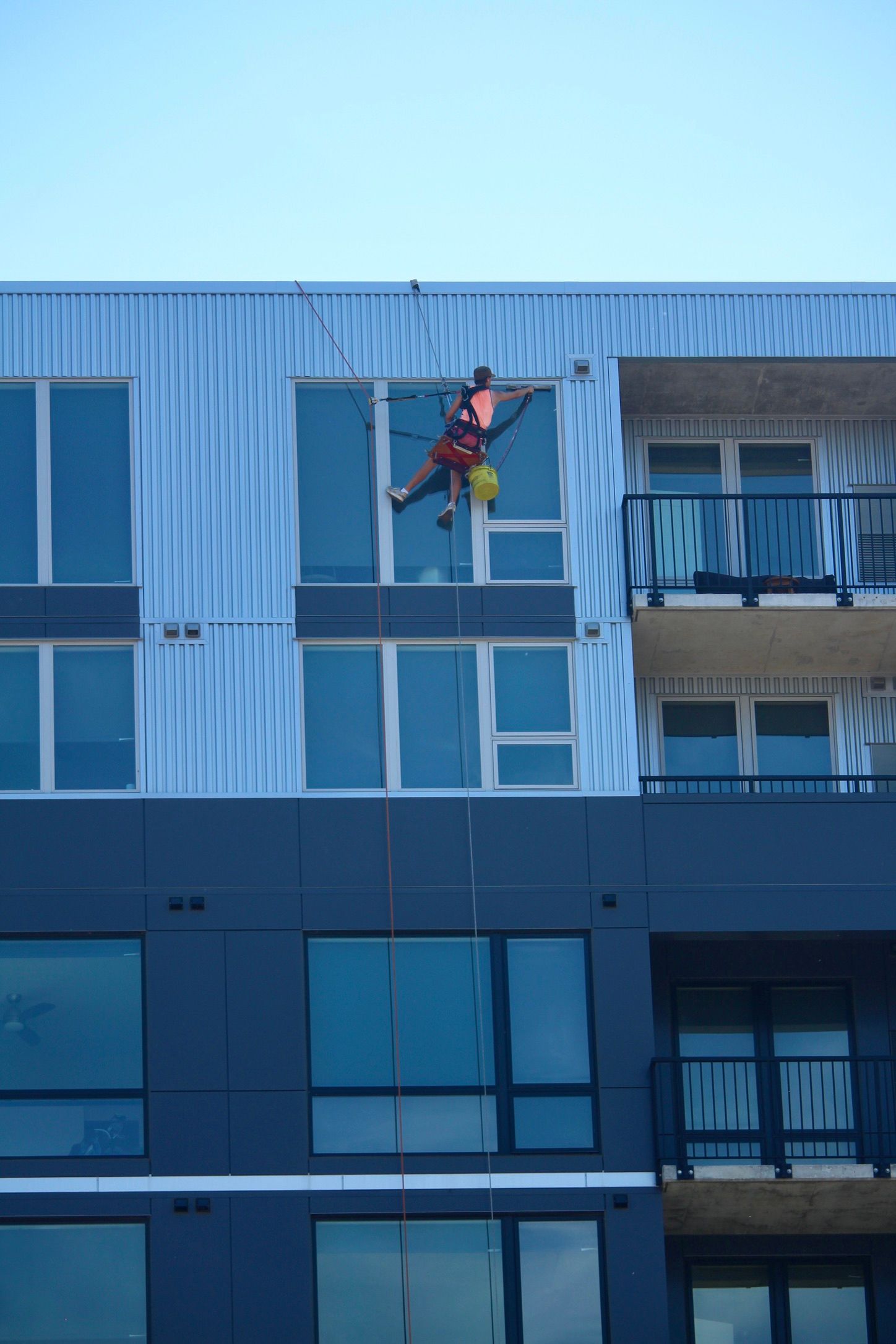 A man is cleaning the windows of a building
