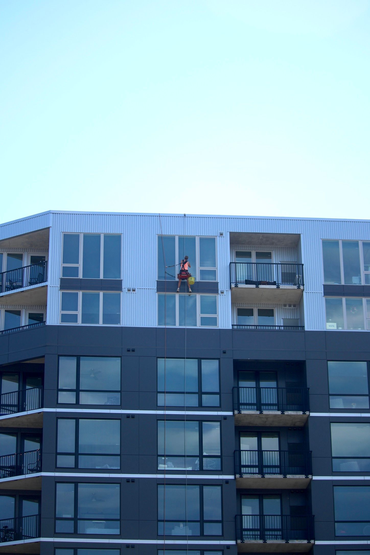 A man is standing on a balcony of a building