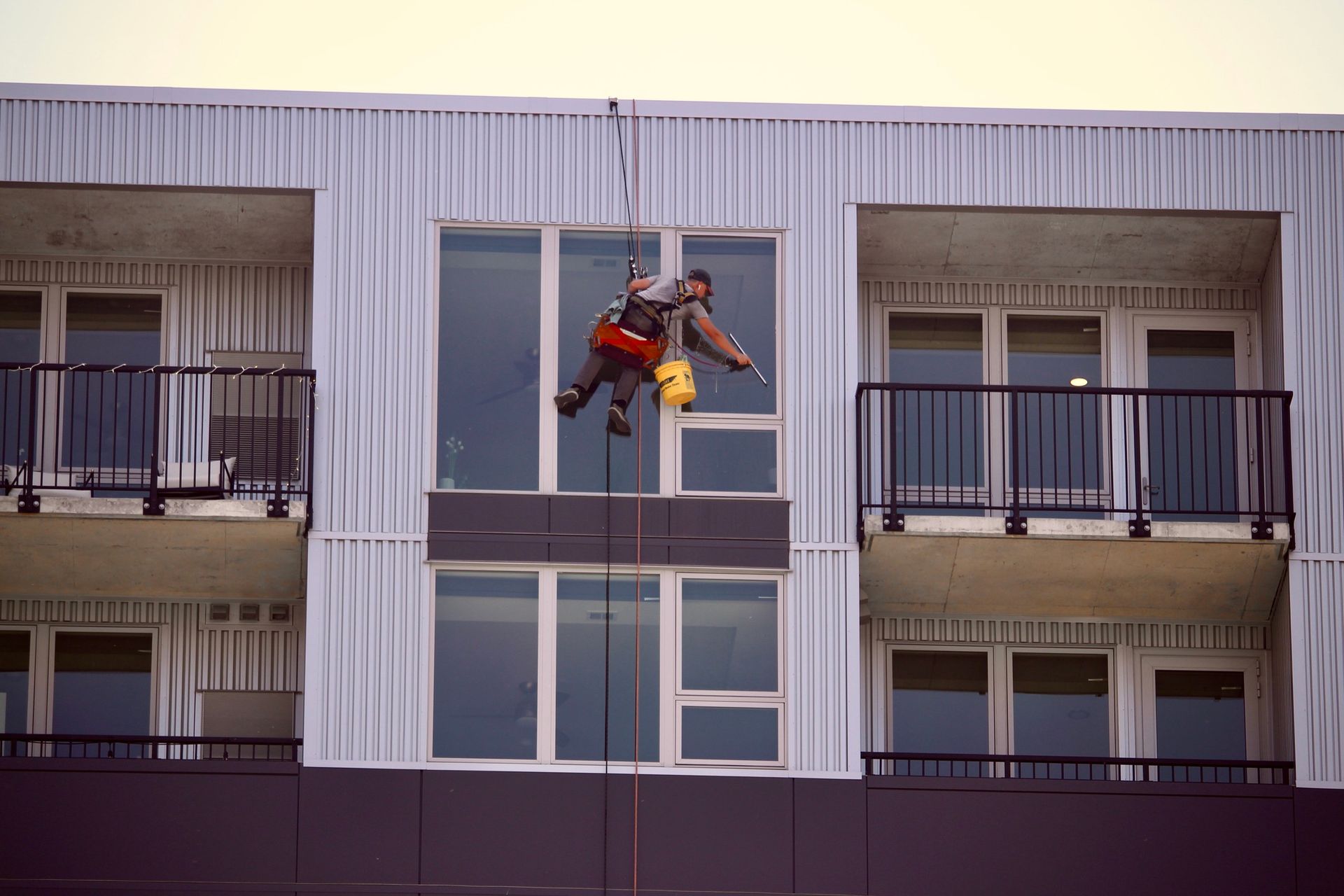 A man is cleaning a window on the side of a building.