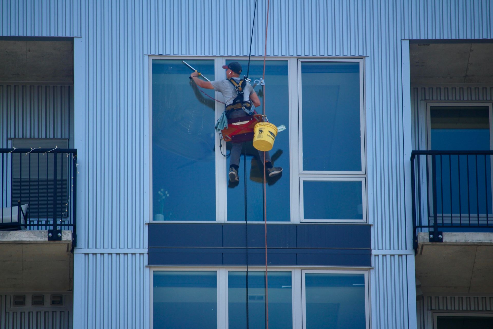 A man is cleaning the windows of a building
