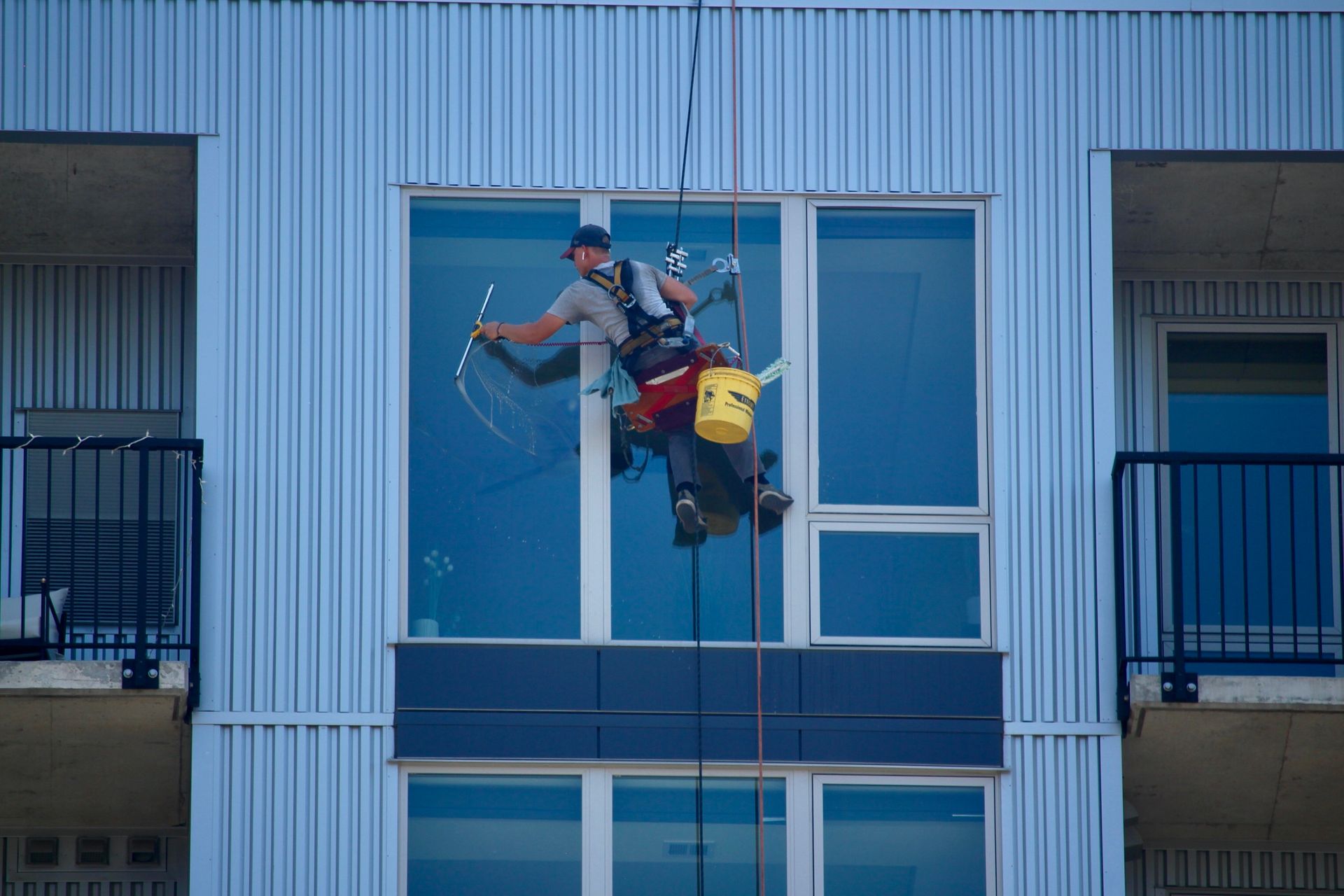 A man is cleaning windows on the side of a building.