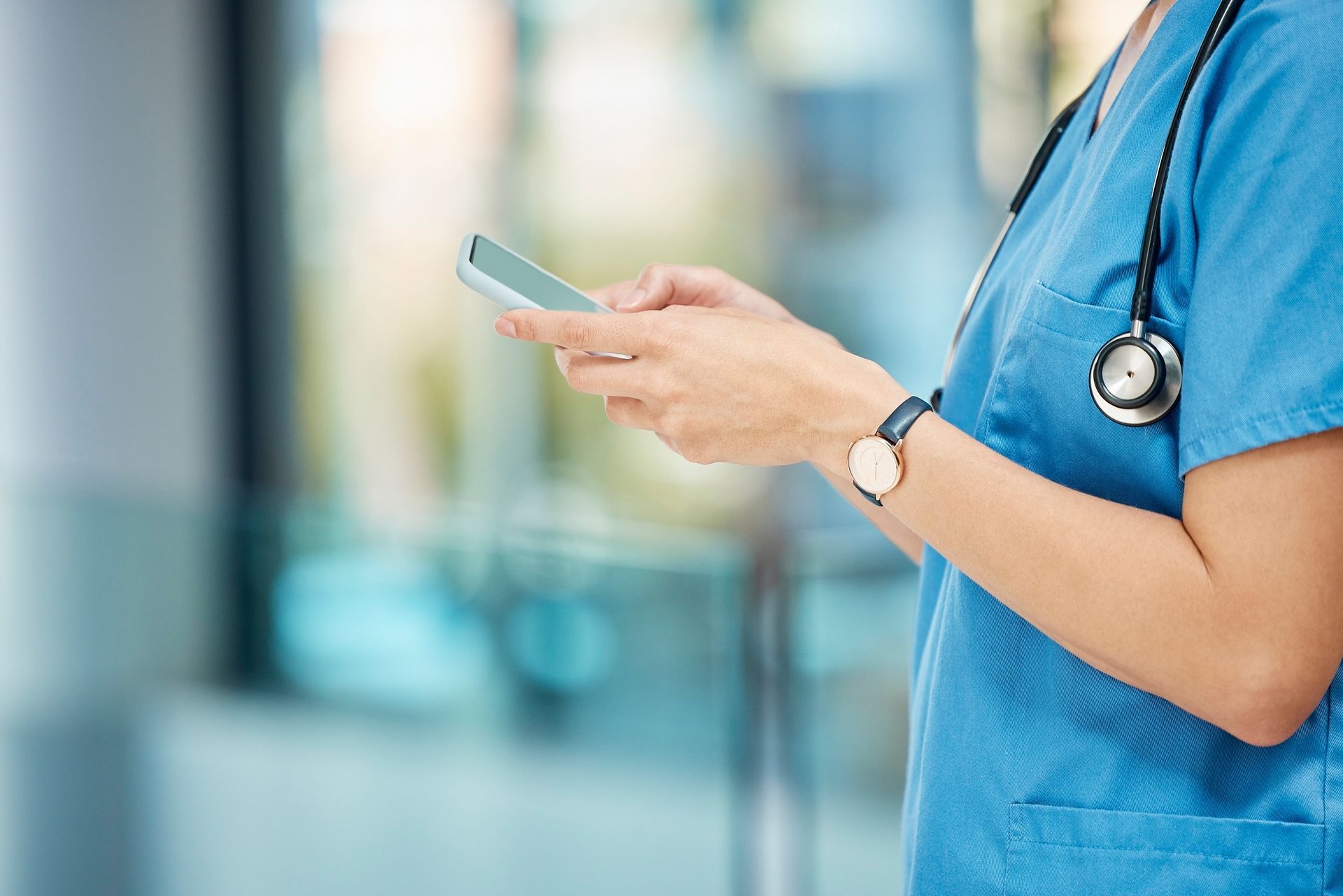 A nurse is using a cell phone in a hospital.