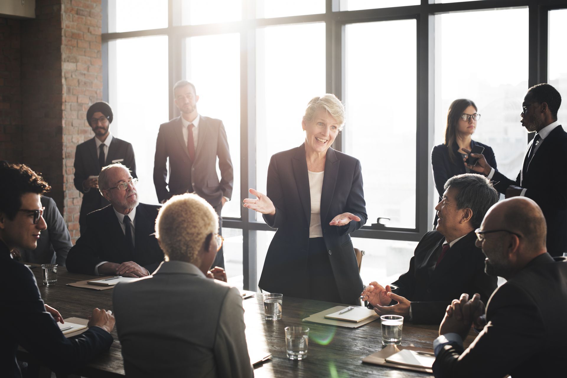 A group of business people are sitting around a table having a meeting.