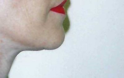 A close up of a woman 's face with red lipstick on her lips.