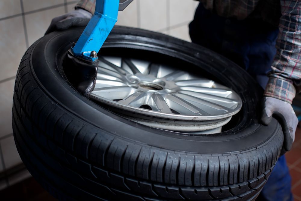 A Man is Changing a Tire on a Machine — Stamford Tyres In Ballarat Central, VIC