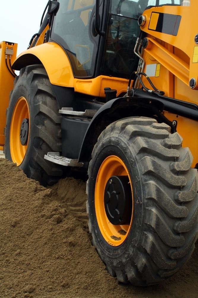 A Yellow and Black Tractor is Sitting in the Dirt — Stamford Tyres In Ballarat Central, VIC