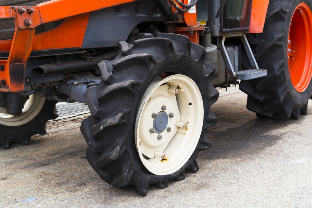 A Tractor With a Flat Tire is Parked on the Side of the Road — Stamford Tyres In Ballarat Central, VIC