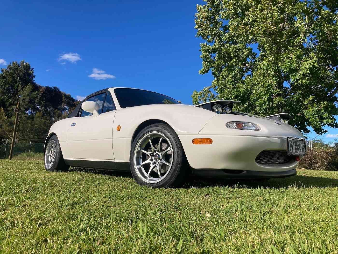 A White Sports Car is Parked on Top of a Lush Green Field — Stamford Tyres In Ballarat Central, VIC