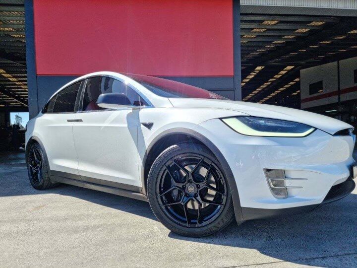 A White Tesla Model X is Parked in Front of a Garage — Stamford Tyres In Ballarat Central, VIC