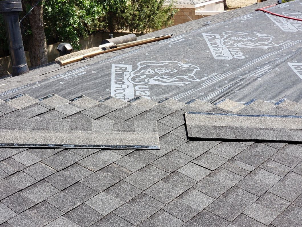 A close up of a roof with shingles being installed.