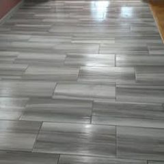 A close up of a gray tile floor in a room.