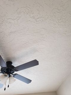 A ceiling fan is hanging from the ceiling of a room.