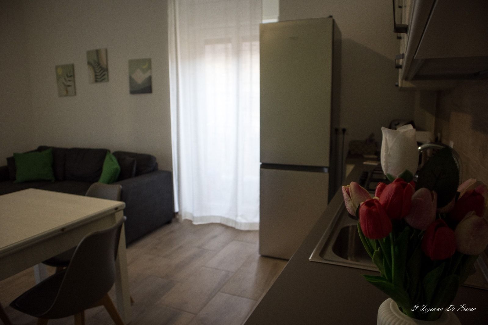 Un soggiorno con un divano, un tavolo e un frigorifero