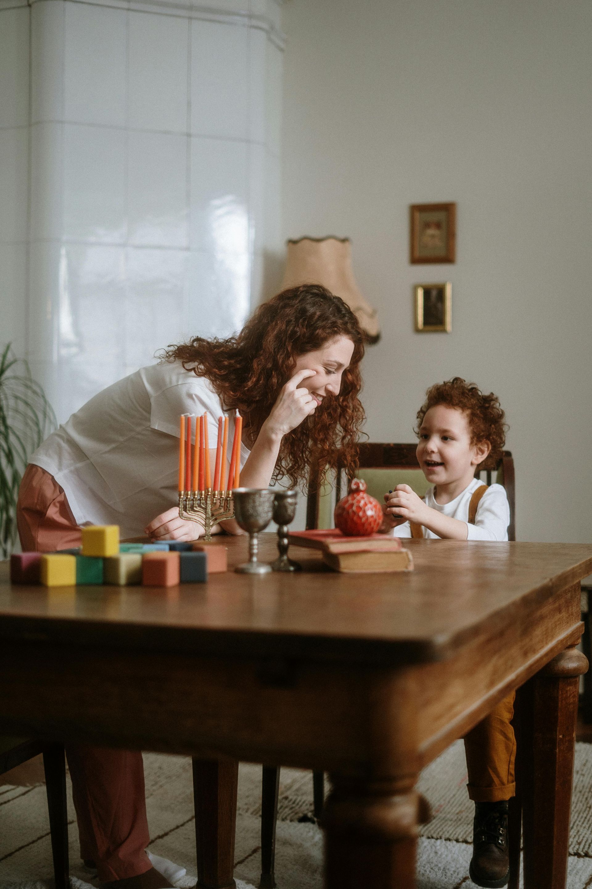 A woman is sitting at a table with a child.