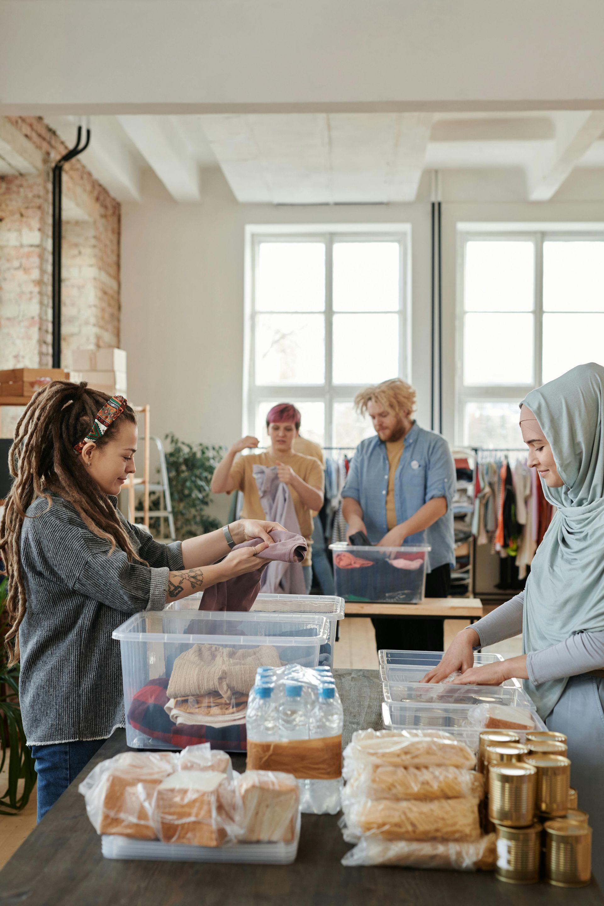 A group of people are standing around a table filled with food.