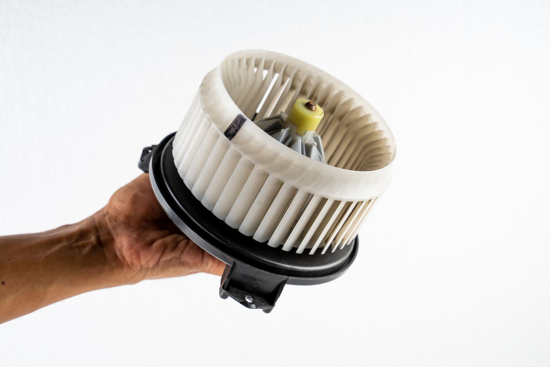 A person is holding a blower in their hand on a white background.