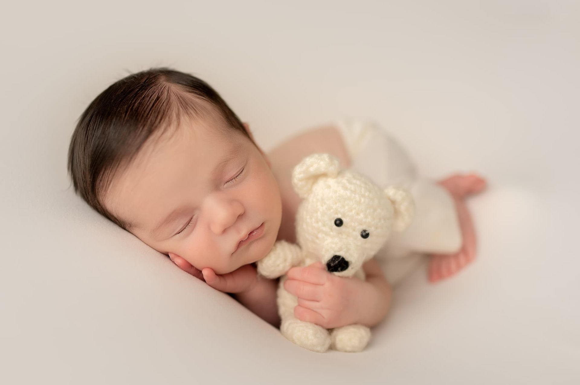 sleeping newborn baby holding teddy bear during Bergen County NJ newborn photography session
