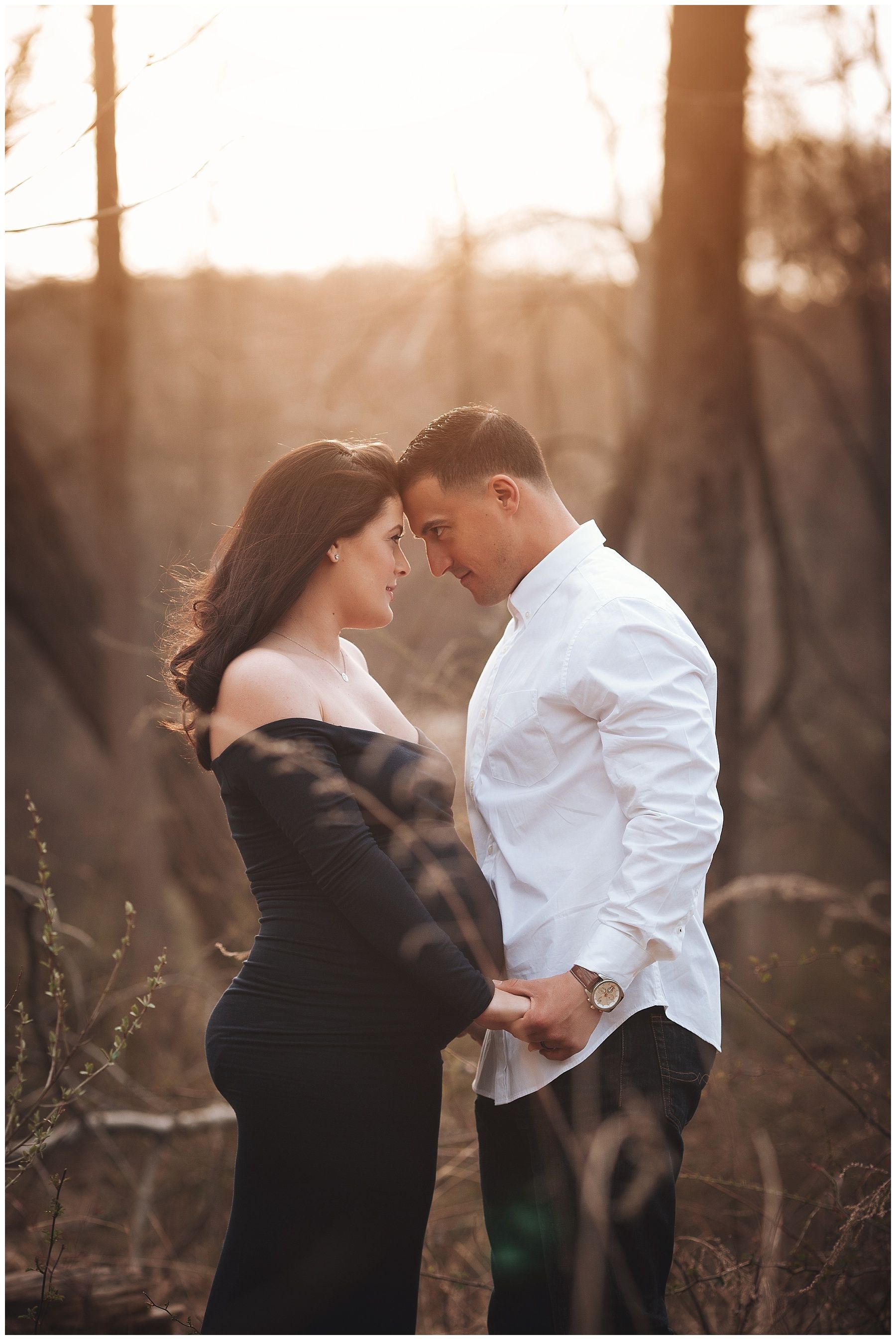 A pregnant woman and a man are looking at each other in the woods.