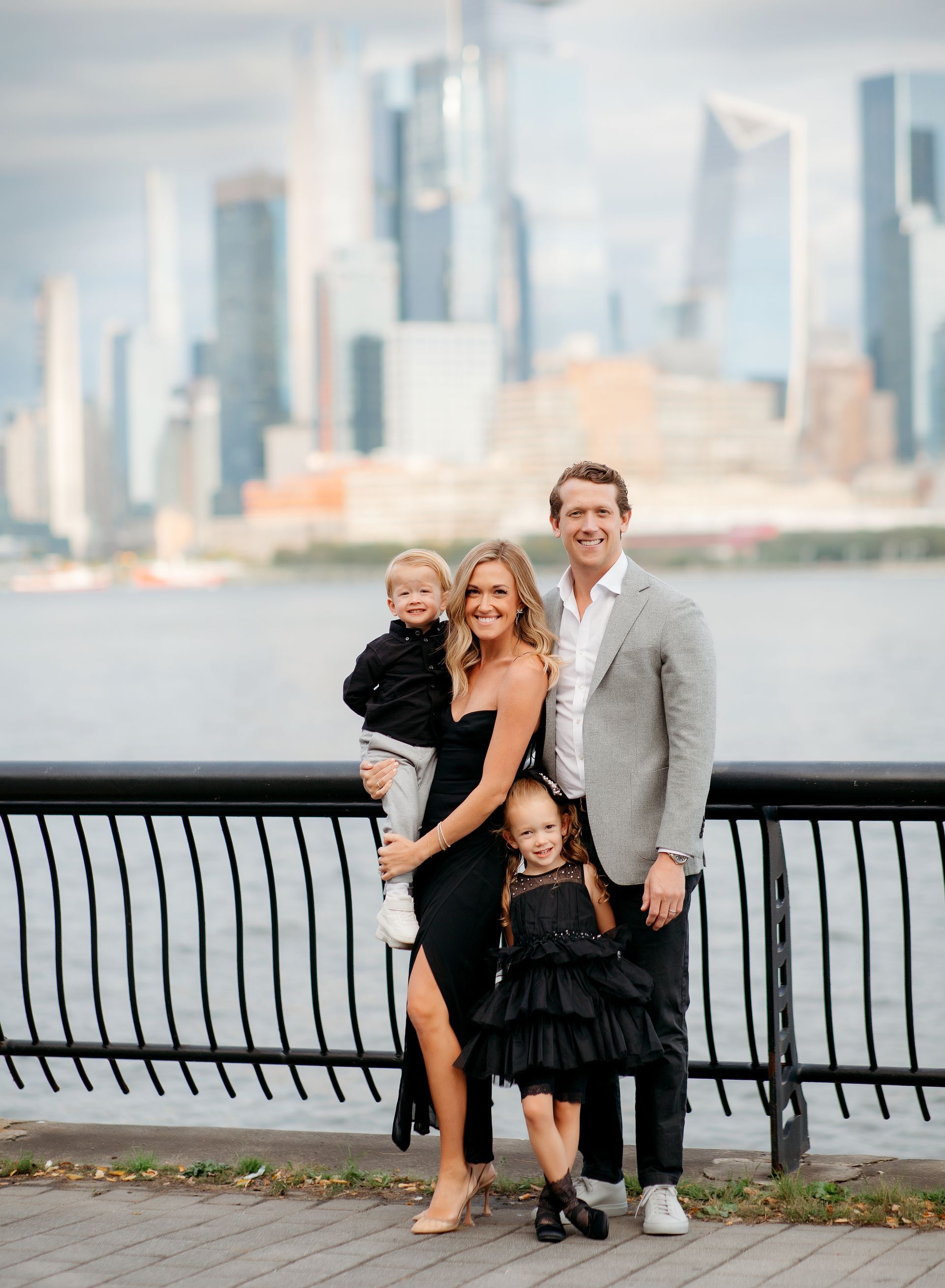 A family is posing for a picture in front of a body of water.