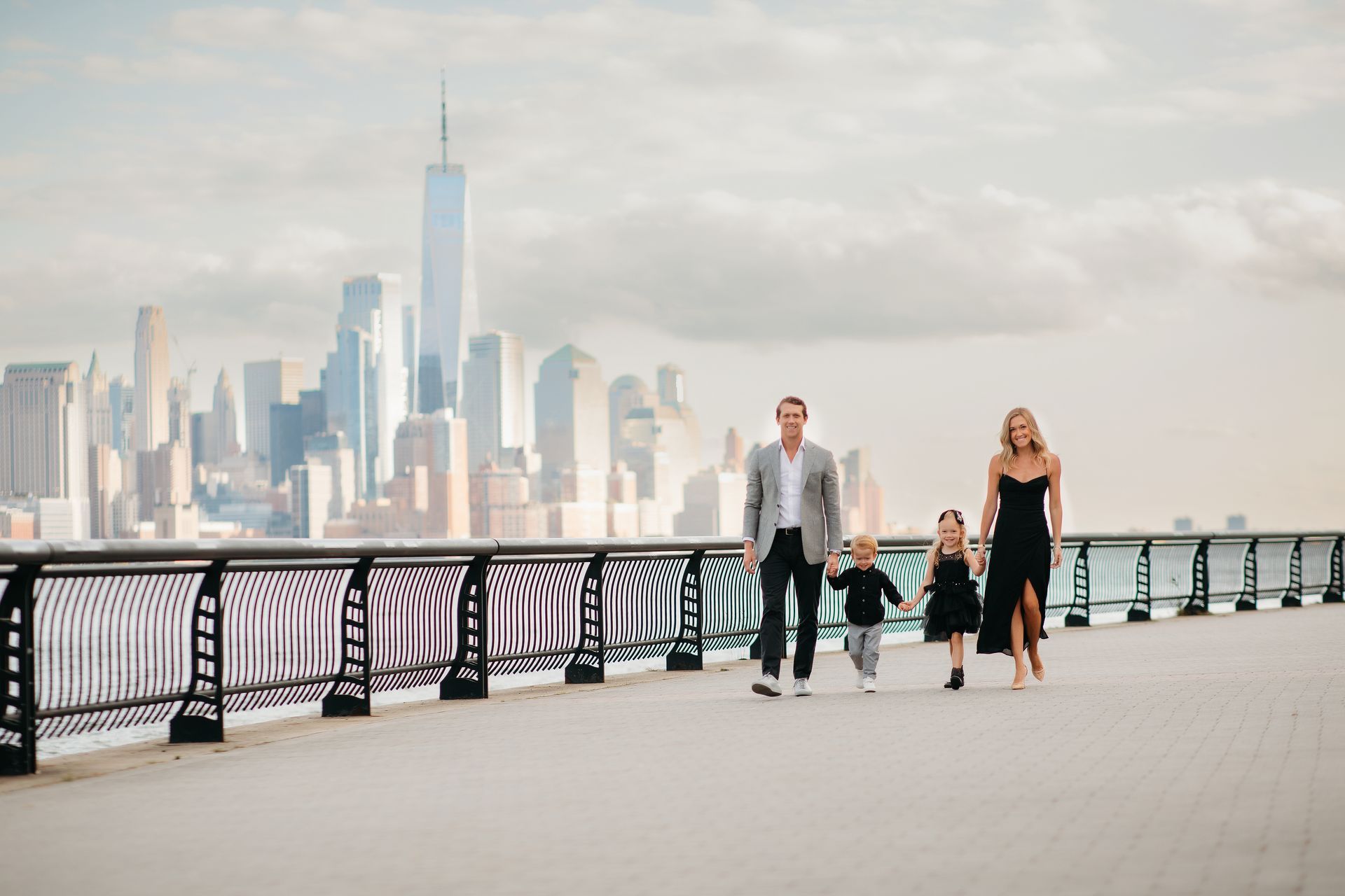 A family is sitting on a bench in front of New York City.