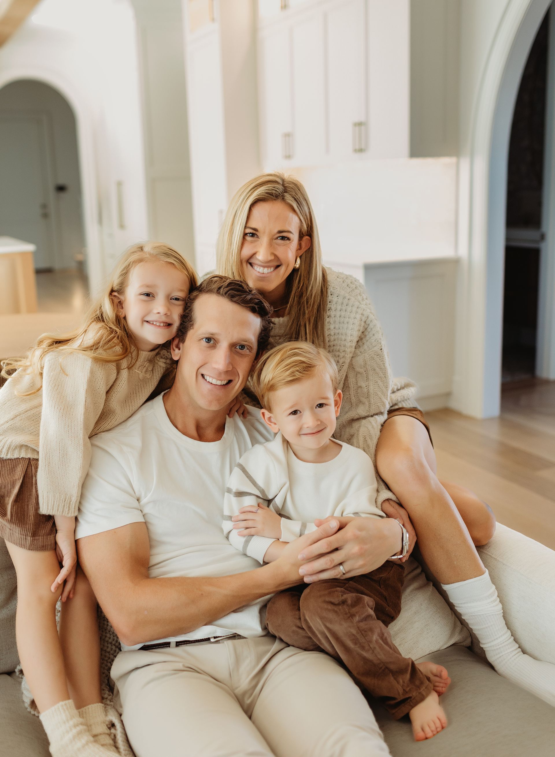 A family is posing for a picture while sitting on a couch.