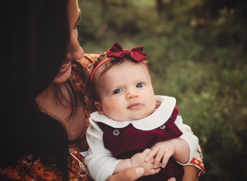 A woman is holding a baby in her arms.